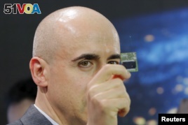 Investor Yuri Milner holds a Starchip, a microelectronic component spacecraft, during an announcement of the Breakthrough Starshot initiative with physicist Stephen Hawking in New York, April 12, 2016.