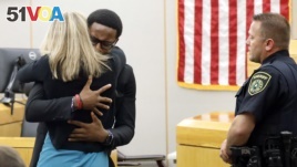 Botham Jean's younger brother Brandt Jean hugs convicted murderer and former Dallas Police Officer Amber Guyger after delivering his impact statement. She was sentenced to 10 years in jail, Oct. 2, 2019, in Dallas.