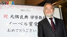 Yoshinori Ohsumi, a professor of Tokyo Institute of Technology smiles in front of a celebration message board after he won the Nobel medicine prize in Yokohama, Japan, October 3, 2016 in this photo released by Kyodo. 