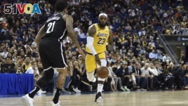LeBron James of the Los Angeles Lakers (R) drives the ball in front of Wilson Chandler of the Brooklyn Nets (L) during the National Basketball Association (NBA) pre-season match between the LA Lakers and Brooklyn Nets at the Mercedes Benz Arena in Shanghai.