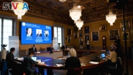 David Haviland, member of the Nobel Committee for Physics, Goran K. Hansson, Secretary General of the Royal Swedish Academy of Sciences and Ulf Danielsson, member of the Royal Swedish Academy of Sciences, announce the winners of the 2020 Nobel Prize in Physics, seen on screen.