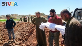 Syrians bury the bodies of victims of a a suspected toxic gas attack in Khan Sheikhun, a nearby rebel-held town in Syria's northwestern Idlib province, April 5, 2017.