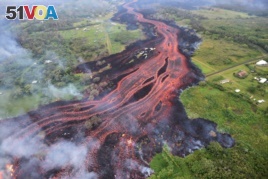 In this Saturday, May 19, 2018, photo released by the U.S. Geological Survey, lava flows from fissures near Pahoa, Hawaii.