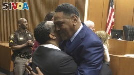Richard Phillips, right, hugs Det. Patricia Little in a courtroom on Wednesday, March 28, 2018, in Detroit, Michigan. Phillips, a Michigan man whose murder conviction was thrown out after he spent 45 years in prison will not face a second trial. (AP Photo/Ed White)