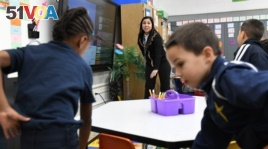 Teaching assistant Dilia Samadova warms up Mrs. Zenobi's kindergarten class for a math lesson with a count to 100 at Our Lady of Peace School, Dec.11, 2019. (CantonRep.com / Ray Stewart)