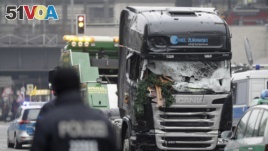 The damaged towing truck is towed away from the crime scene in Berlin, Germany, Tuesday, Dec. 20, 2016, the day after the truck ran into a crowded Christmas market.