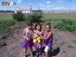 Young members of the Crow Creek community showing the fruits of their gardening labors. Photo courtesy of the Crow Creek Fresh Food Initiative