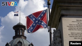 The U.S. flag and South Carolina state flag flies at half staff to honor the nine people killed in the Charleston murders as the confederate battle flag also flies on the grounds of the South Carolina State House in Columbia, SC, June 20, 2015.