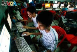 FILE - Two students use computers at an internet cafe near their dormitory in Hanoi, Vietnam, September 27, 2012. (AP Photo/Na Son Nguyen)