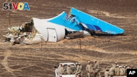 In this photo made available Nov. 2, 2015, and provided by Russian Emergency Situations Ministry, Egyptian military forces approach a plane's tail at the wreckage of a passenger jet bound for St. Petersburg in Russia that crashed in Hassana, Egypt.