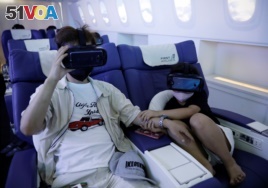 A girl holds her father's hand as she uses a virtual reality (VR) device at a check-in desk at First Airlines, that provides VR flight experiences, including 360-degree tours of cities and meals, amid the COVID-19 pandemic in Tokyo, Japan August 12, 2020.