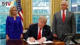 U.S. President Donald Trump signs an executive order on immigration policy with DHS Secretary Kirstjen Nielsen and Vice President Mike Pence at his sides in the Oval Office at the White House in Washington, U.S., June 20, 2018. (REUTERS/Leah Millis)