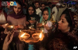 Sufi devotees carry clay oil lamps at a shrine of Madhu Lal Shah Hussain, a poet also regarded as a Sufi saint, during an annual festival to celebrate him in Lahore, Pakistan, Saturday, March 26, 2016. (AP Photo/K.M Chaudary)