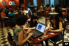 Three young Vietnamese girls use a laptop and smart phones to go online at a cafe in Hanoi, VietNam Wednesday, May 14, 2013. (AP PHOTO) 