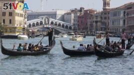 FILE - Tourists tour the Grand Canal on traditional Gondola Venetian boats, in Venice, Italy, Sept. 28, 2014. (AP Photo/Andrew Medichini)