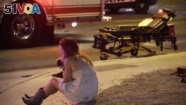 A woman sits on the street at the scene of a shooting outside of a music festival along the Las Vegas Strip. Months after Facebook and Google announced major efforts to curb the spread of false stories pretending to be news, it's still a problem, most rec