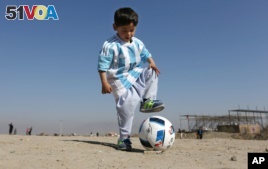 Murtaza Ahmadi, a 5-year-old Afghan Lionel Messi fan plays with a soccer ball. He and his family recently moved to Pakistan due to safety concerns.