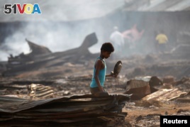  A boy searches for useful items among the ashes of burnt down dwellings after a fire destroyed shelters at a camp for internally displaced Rohingya Muslims in Myanmar's western Rakhine State near Sittwe, May 3, 2016.
