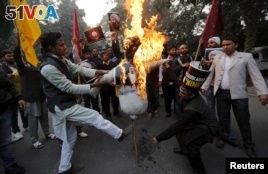 Shi'ite Muslims burn a representation of Saudi King Salman bin Abdulaziz during a protest against the execution in Saudi Arabia of cleric Nimr al-Nimr, in front of Saudi Arabia's embassy in New Delhi, India, Jan. 4, 2016.