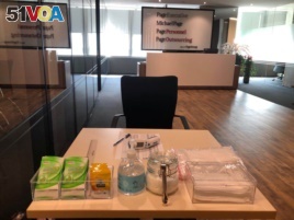 A thermometer, hand sanitizer and masks are pictured in the reception area at PageGroup's office after reopening, April 29, 2020.