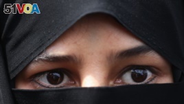 FILE - A veiled Iranian woman attends a rally after the Friday prayers in Tehran, Iran.