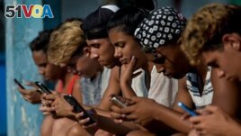 FILE - Young people use a hotspot to connect to the internet, in Havana, Cuba, June 06, 2019. 