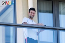 Tennis star Novak Djokovic stands on his balcony at the accommodation where he is quarantining in advance of the Australian Open to be played in Melbourne, in North Adelaide, Australia, January 19, 2021. (AAP Image/Morgan Sette via REUTERS)