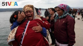 Relatives cry while waiting for news on missing family members who were on a ferry that sank yesterday in Lake Toba, at Tigaras Port, Simalungun, North Sumatra, Indonesia June 19, 2018. (REUTERS/Albert Damanik)