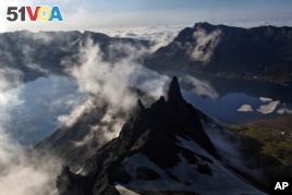  In this Wednesday, June 18, 2014 photo, clouds float over the peak of Mt. Paektu in North Korea's Ryanggang province. More than a thousand years ago, a huge volcano straddling the border between North Korea and China was the site of one of the biggest eruptions in history.