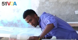 Shafii Ali returned home to Somalia after living in a refugee camp in Kenya. He is now learning to make window frames.