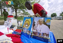 A vendor arranges portraits of Pope Francis outside of the Lubaga Cathedral in Kampala, Uganda, Nov. 13, 2015.  The pope will be in Uganda on November 28 and 29 (AFP/ ISAAC KASAMANI).