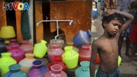 In this Thursday, July 18, 2019, photo, a boy waits at a water distribution point in Chennai, capital of the southern Indian state of Tamil Nadu. (AP Photo/Manish Swarup)