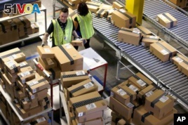 In this file photo, Amazon employees organize outbound packages at an Amazon.com Fulfillment Center on 