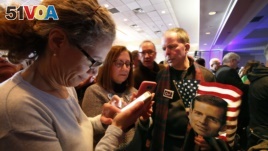 People check election returns on their phones at the election night party for Conor Lamb, the Democratic candidate for the March 13 special election in Pennsylvania's 18th Congressional District, on Canonsburg, Pa., Tuesday, March 13, 2018. (AP Photo)