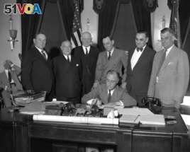 FILE - President Franklin D. Roosevelt signs a bill at the White House, June 16, 1933.