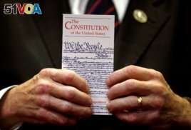 FILE - A member of Congress holds a copy of the U.S. Constitution during a press conference in the U.S. Capitol in Washington June 20, 2017.