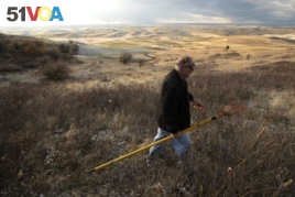 In this Oct. 28, 2019, photo, amateur botanist David Benscoter, of The Lost Apple Project, walks above an orchard in the Steptoe Butte area near Colfax, Wash. Benscoter and fellow botanist E.J. Brandt have rediscovered at least 13 long-lost apple varieties over the past several years in homestead orchards, remote canyons and windswept fields in eastern Washington and northern Idaho. (AP Photo/Ted S. Warren)