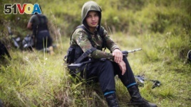 FILE - Juliana, a 20-year-old rebel fighter for the 36th Front of the Revolutionary Armed Forces of Colombia, or FARC, rests from a trek in the northwestern Andes of Colombia, in Antioquia state, Jan. 6, 2016. 