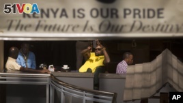 A man takes photographs of the mall with his smartphone while he sits in a cafe at the reopened Westgate Shopping Mall in Nairobi  July 18, 2015. (AP Photo/Ben Curtis)