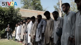 Arrested Islamic State fighters stand outside Afghan police headquarters in Nangarhar, Afghanistan