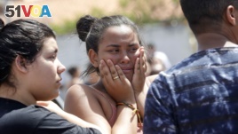 A student cries outside the Raul Brasil State School in Suzano, the greater Sao Paulo area, Brazil, Wednesday, March 13, 2019. The state government of Sao Paulo said two teenagers, entered the school and began shooting at students. (AP Photo/Andre Penner)