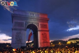 The Arc de Triomphe is lit up with the colors of the French national flag and by fireworks set off by French soccer fans celebrating France's World Cup victory over Croatia, in Paris, France, Sunday, July 15, 2018.