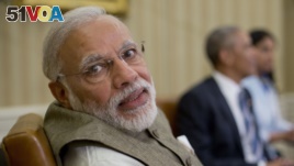 Indian Prime Minister India Narendra Modi looks over his shoulder to speak with an aide during his meeting with President Barack Obama in the Oval Office of the White House in Washington, June 7, 2016. The prime minister accepted more than 200 artifacts unlawfully removed from India during his trip to Washington.