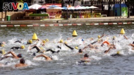 Swimmers compete in a race organized by the Paris Swim association, in the La Villette basin, Paris, Sept. 3, 2017.