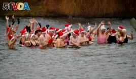 Members of the Berliner Seehunde (Berlin seals) swimming club take a bath at the lake Oranke during their traditional Christmas swimm in Berlin, Germany, Dec. 25, 2017.