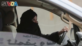 Aziza Yousef drives a car on a highway in Riyadh, Saudi Arabia, as part of a campaign to defy Saudi Arabia's ban on women driving, March 29, 2014. (AP Photo/Hasan Jamali, File)