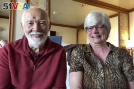 In this image from a video taken on Wednesday, Feb. 12, 2020, Paul Molesky and Cheryl Molesky are interviewed through Skype in their cabin room on the Diamond Princess, anchored at a port in Yokohama, near Tokyo.