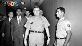 FILE - Heavyweight boxing champion Muhammad Ali is escorted from the Armed Forces Examining and Entrance Station in Houston by Lt. Col. J. Edwin McKee, after Ali refused Army induction, April 28, 1967. Ali died at age 74, June 3, 2016.