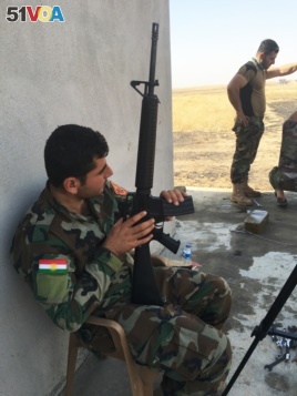 Iraqi Kurdish Peshmerga fighter outside a house recently recaptured from IS extremists on the Mosul frontline.