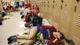 Emily Hindle lies on the floor at an evacuation shelter set up at Rutherford High School, in advance of Hurricane Michael, which made landfall, in Panama City Beach, Fla., Oct. 10, 2018.